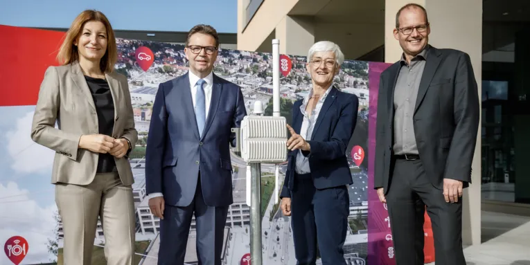 Zwei und zwei Männer neben einer Antennen-Kontruktion.
